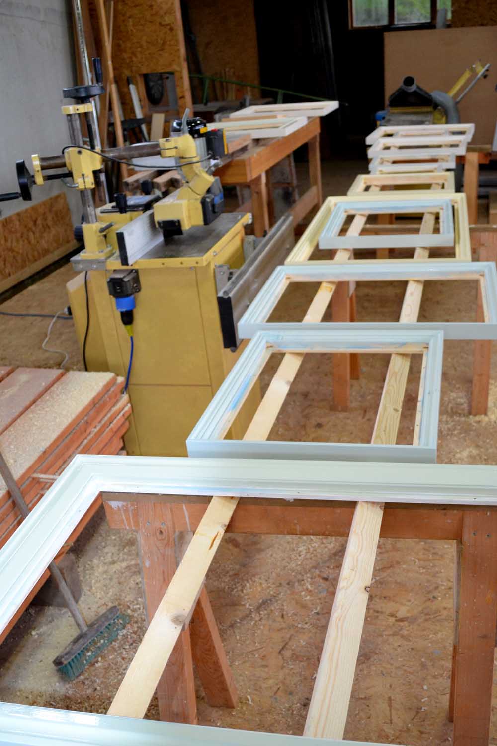 Painted frames laid out in the workshop