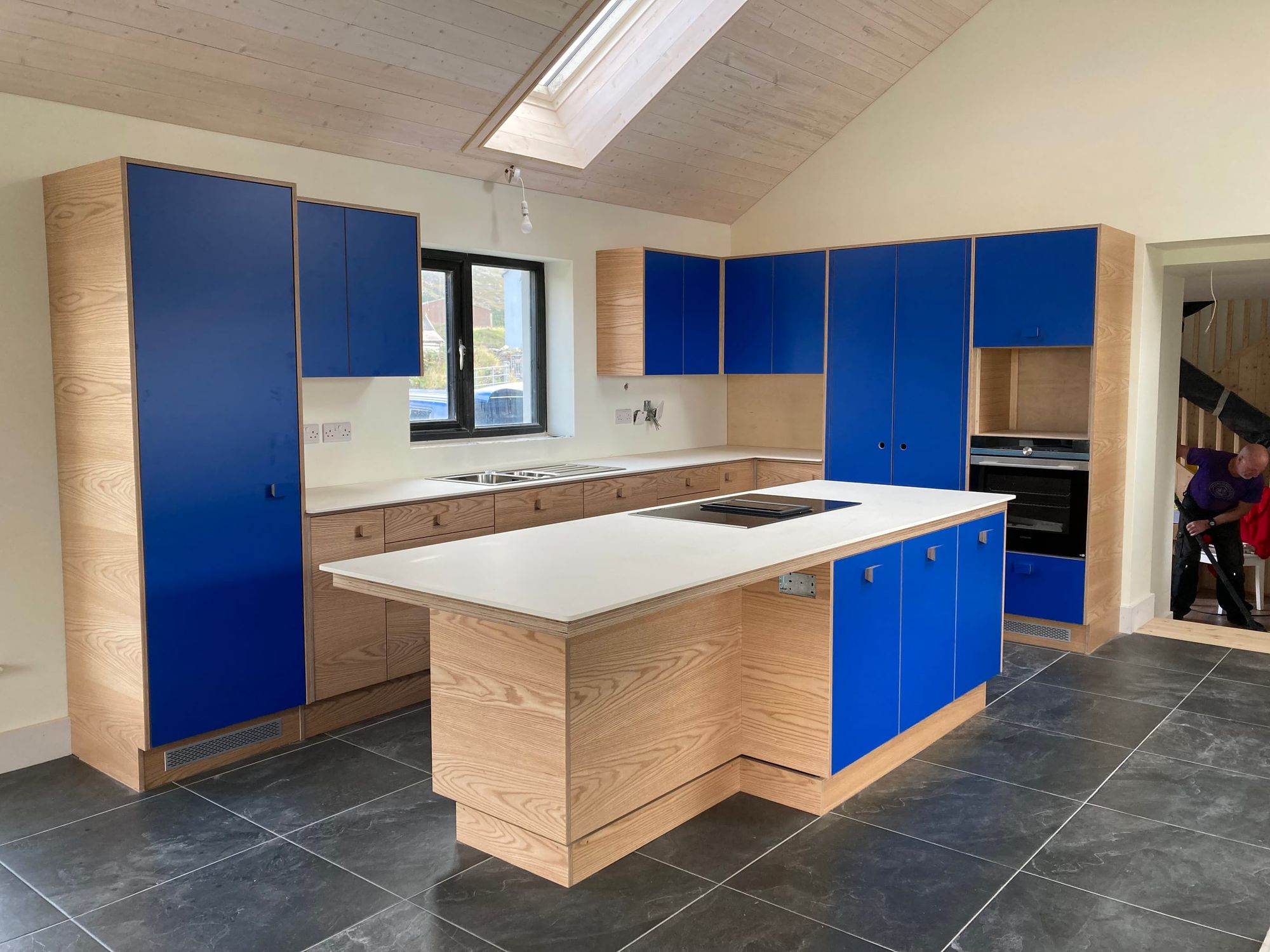 Kitchen in blue and pale timber with an island