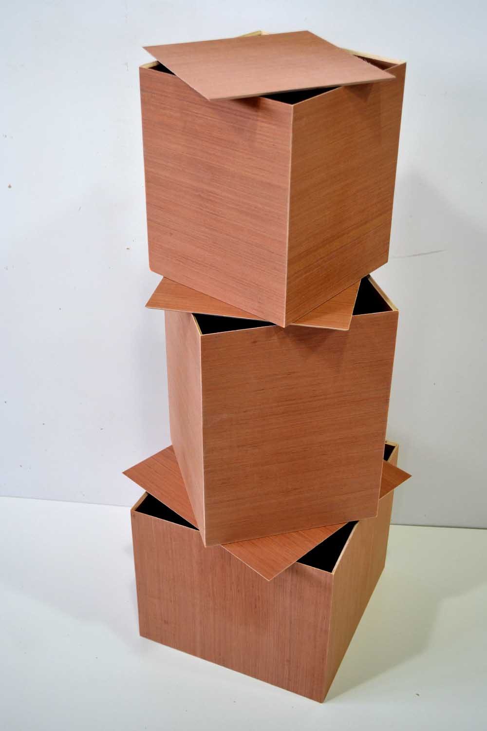Three stacked wooden boxes with their lids ajar
