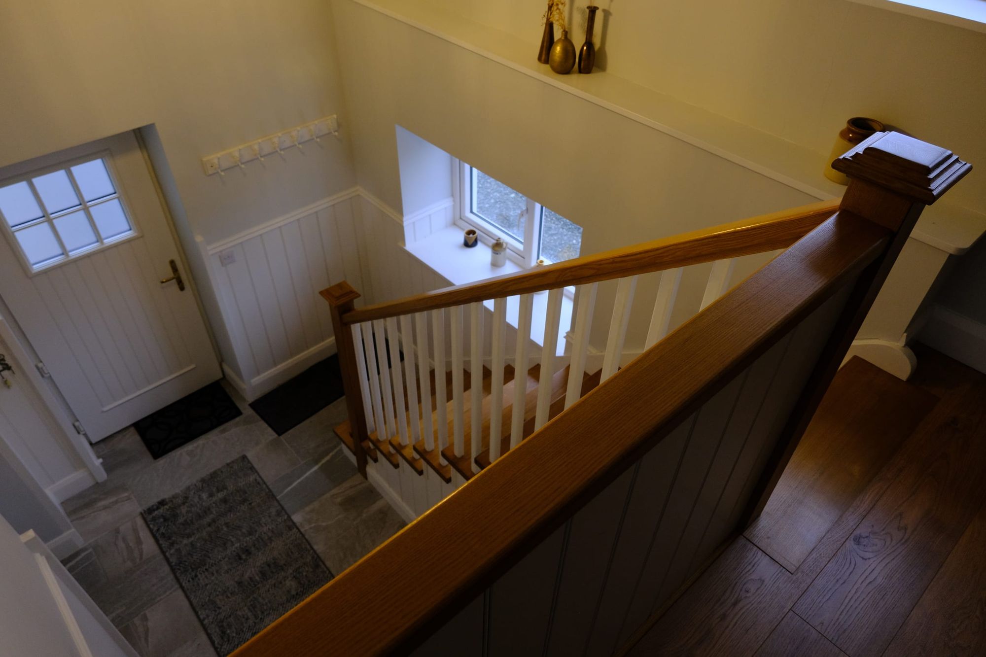 Hall stair with painted balusters and a timber rail, seen from the landing